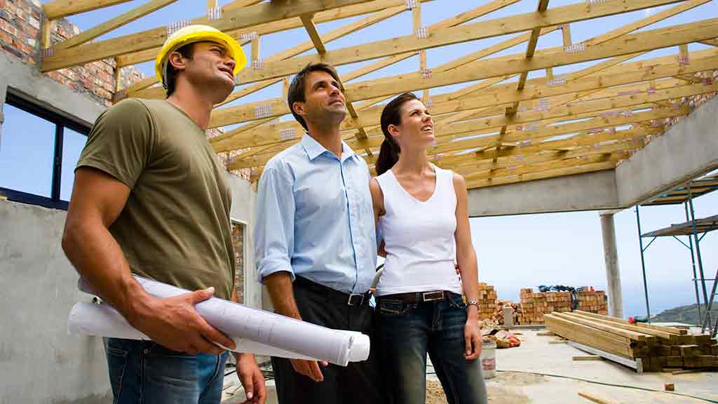 couple and builder in a half built house