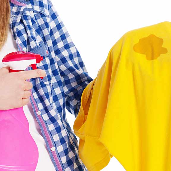 woman spraying stained clothes sq