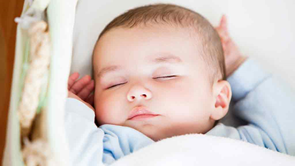 baby in a portable cot