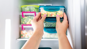 person putting food into a freezer