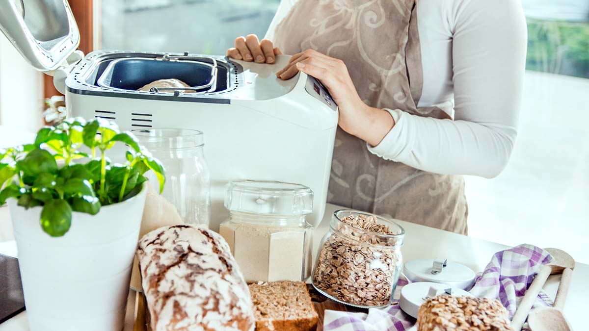 woman using bread maker at home