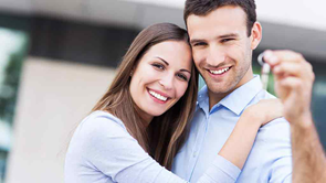 couple with keys outside home