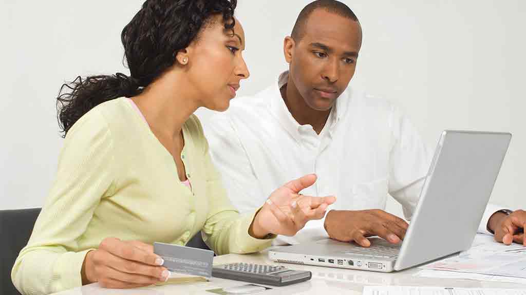 couple looking at laptop and calculator