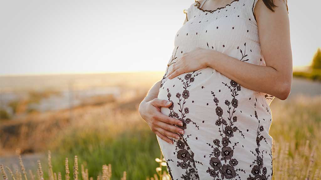 pregnant woman standing in a field