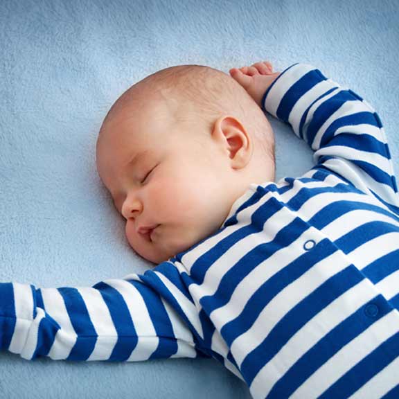 young baby asleep on bed sq