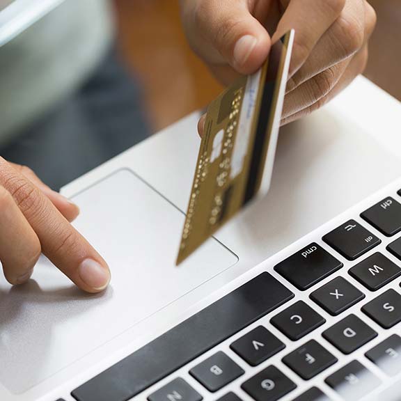 person holds credit card over keyboard square