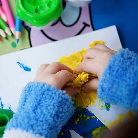 child playing with playdough square