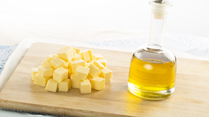 chopping board with butter and bottle of olive oil