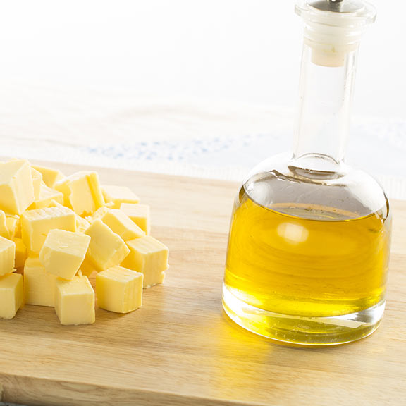 chopping board with butter and bottle of olive oil square 